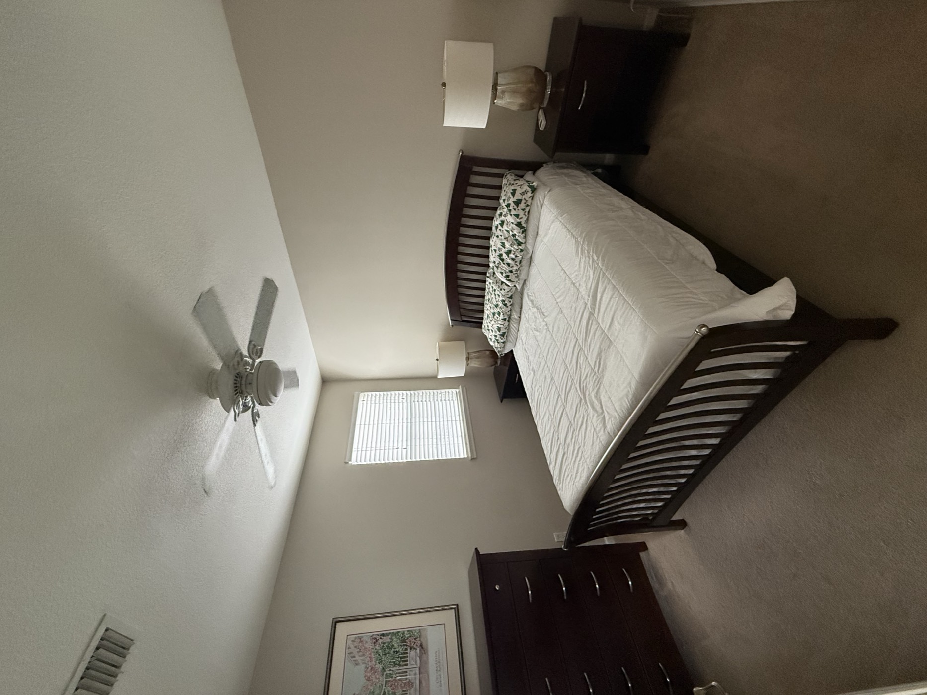 Bedroom with a queen bed, dresser, and nightstands